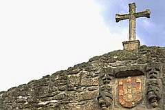Cruz e brasão da igreja junto ao castelo